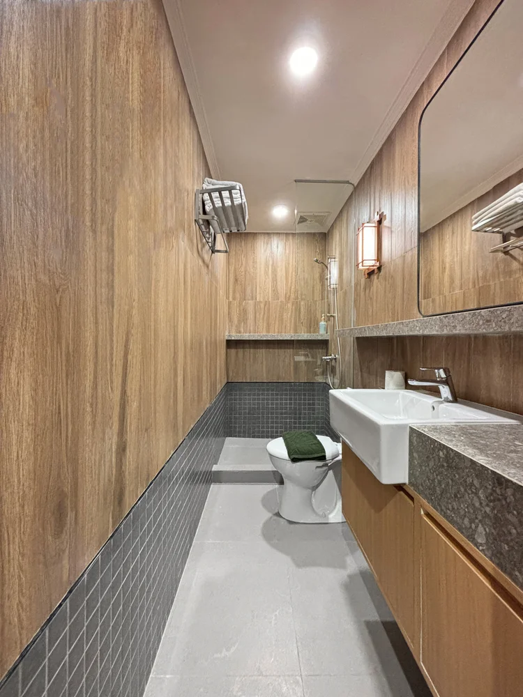 Kawaguchi: Modern bathroom with wood-look walls; soap and shampoo the same in every unit.