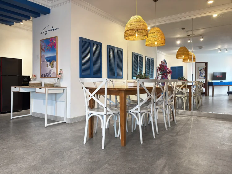 Santorini: A long dining table for eight, with Santorini-blue shutters on the wall.