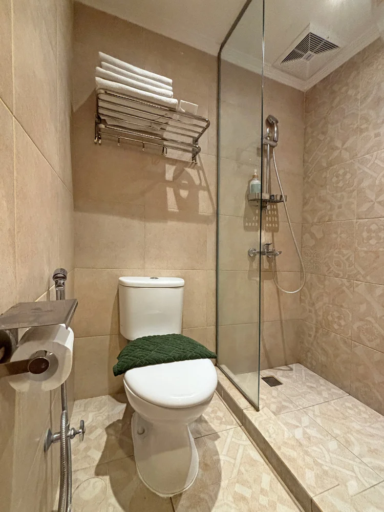 Ubud: Bathroom with a glass-walled shower, cleaned by our own trained team to CHSE standard before every check-in.