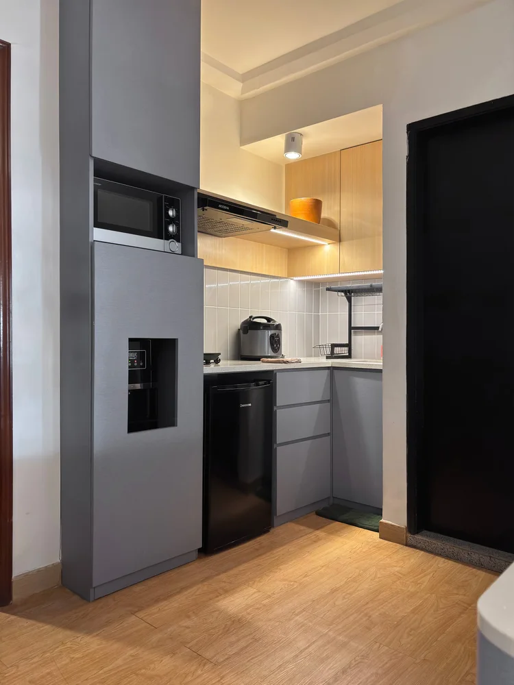 Den Haag: A small kitchen with a mini fridge and microwave shelf, tucked under the loft bed.