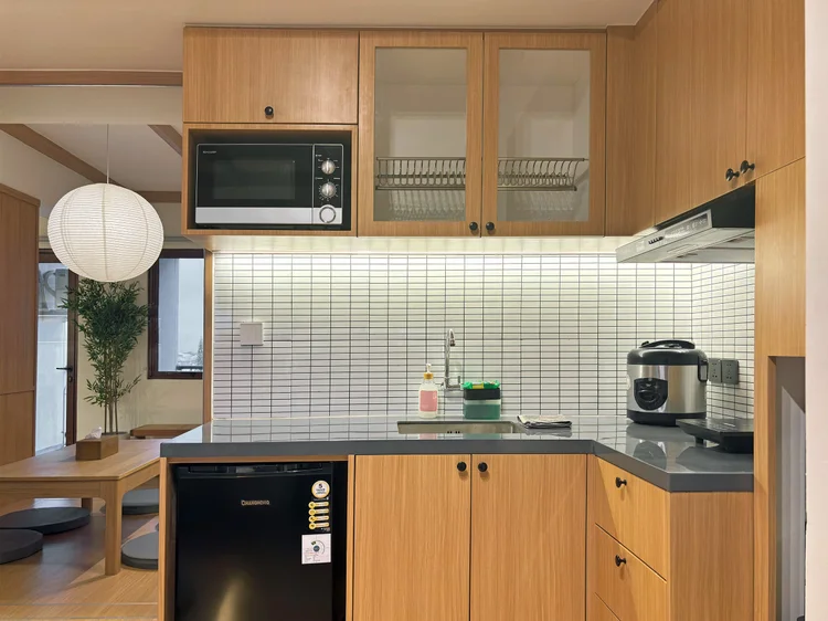 Nara: Open kitchen with microwave, rice cooker and induction hob.