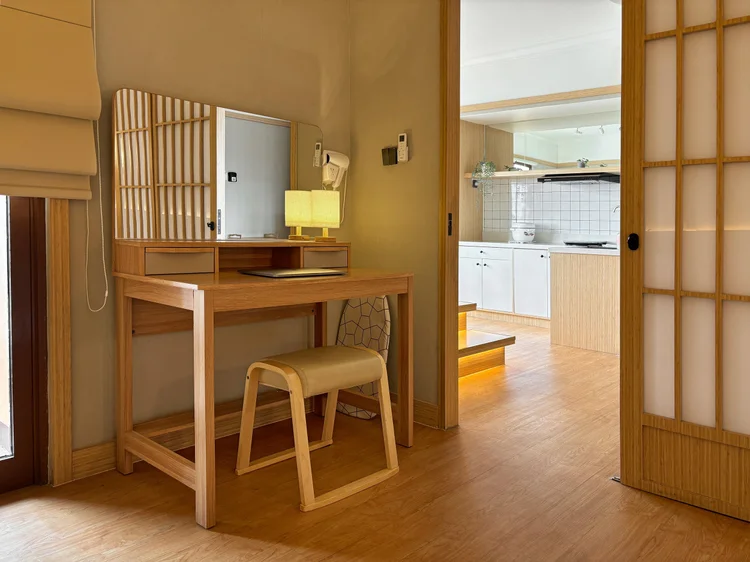 Fukuoka: Timber dressing table with a stool in the bedroom, the kitchen in view across the way.