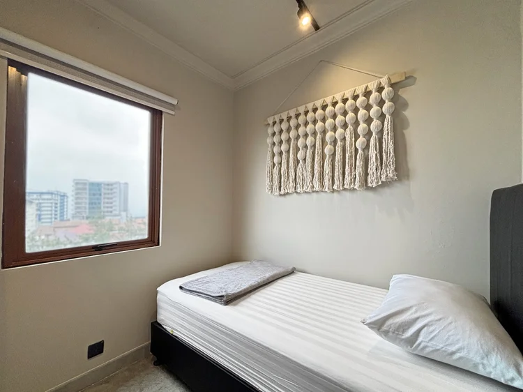 Saitama: A bedroom with a single bed under the window and a macrame hanging.