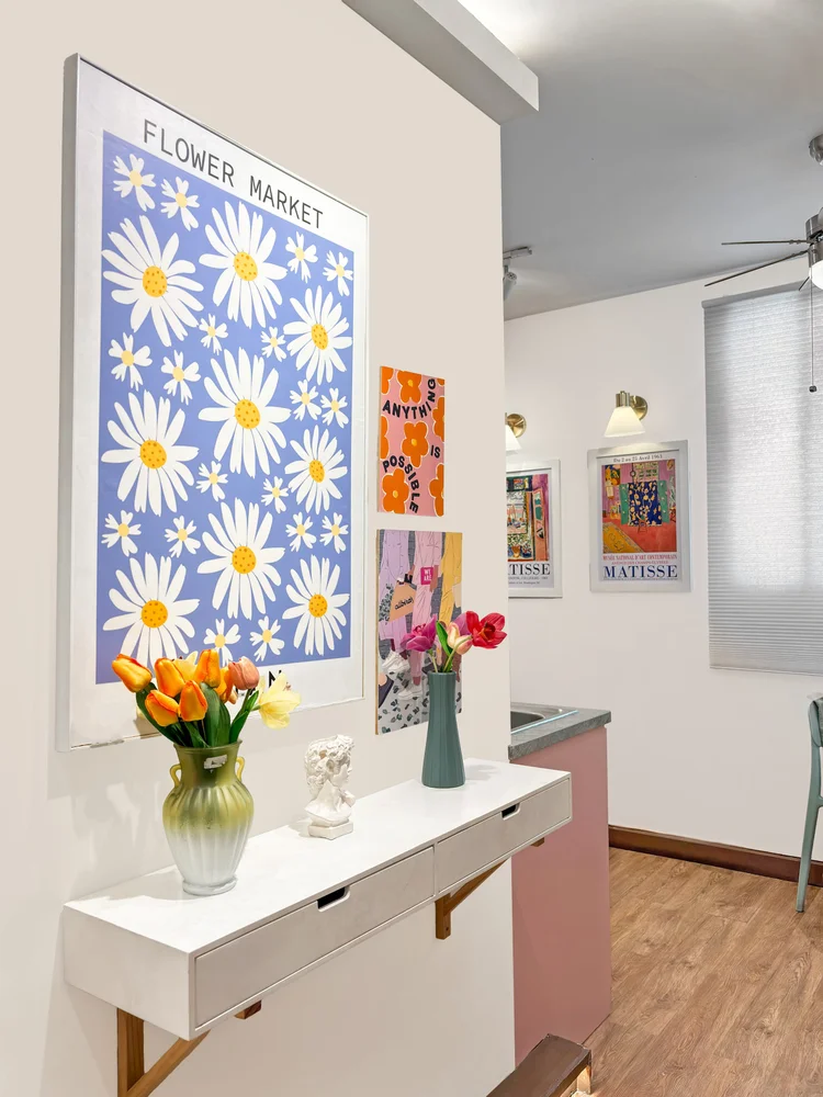 Milan: A console shelf with flowers and a Flower Market poster, Milan's pastel palette.