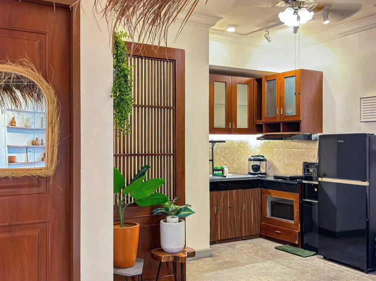 Ubud: A large open kitchen, with a lattice wood shelf and a double-door fridge.