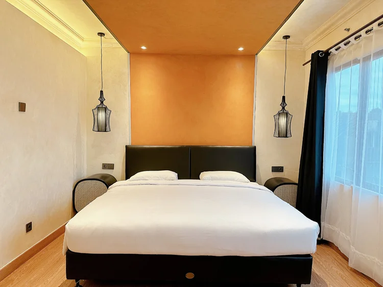 Melbourne: A 200x200 cm king bed facing the curtained window, a pendant lamp on each side.