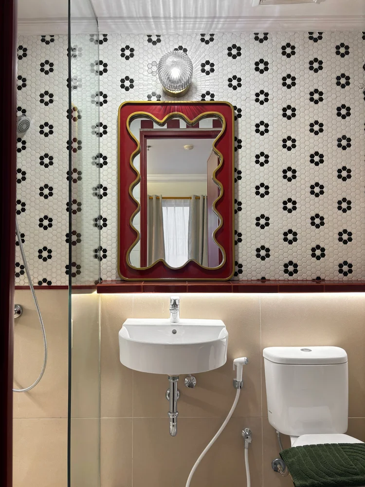 Chamonix: Sink and toilet with black-and-white floral tiles.
