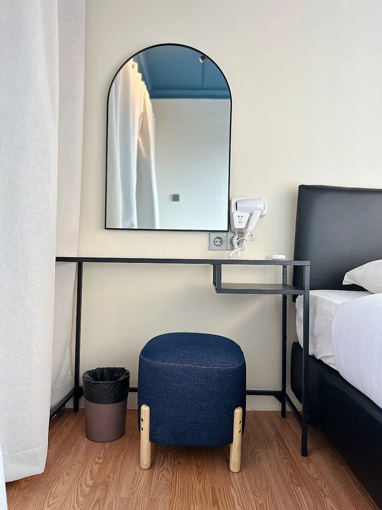 Boston: Dressing table with an arched mirror and a stool, right beside the bed.