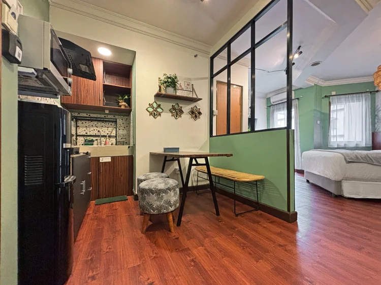 Panama: Dining table for four with a bench and stools, the bed area behind the glass partition.
