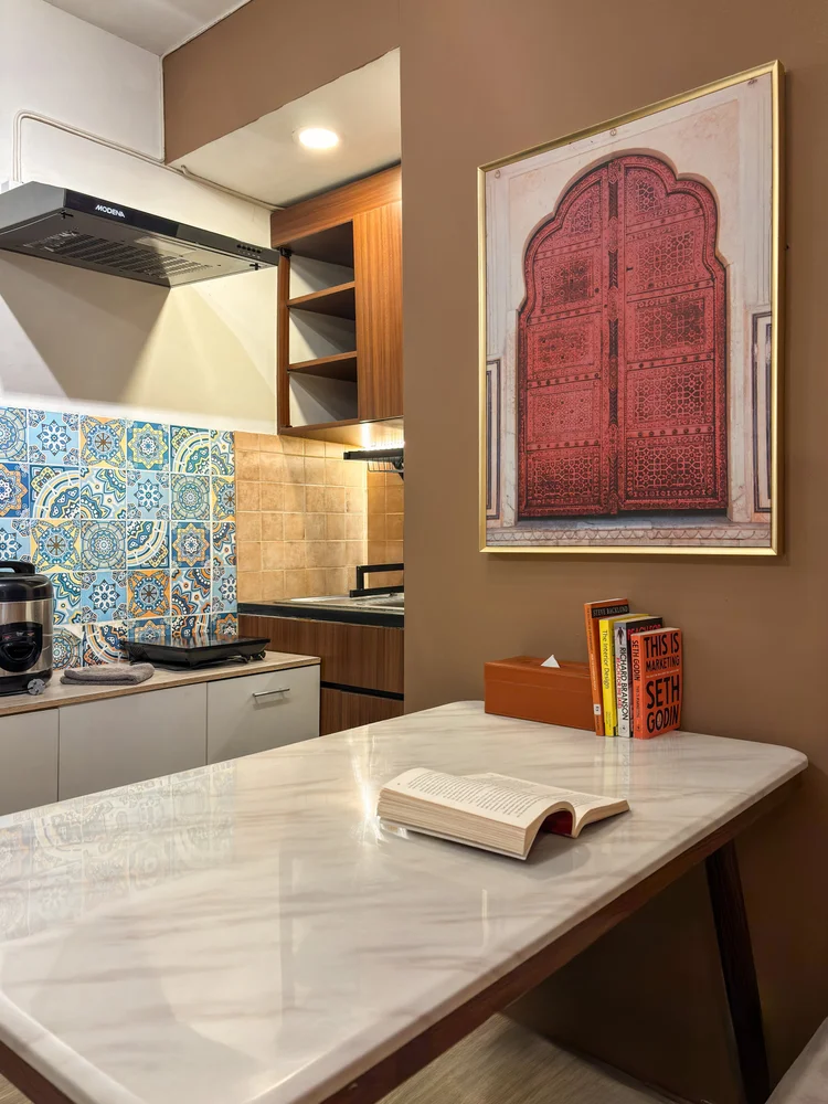 Ankara: A marble dining table in front of the open kitchen with patterned tiles.