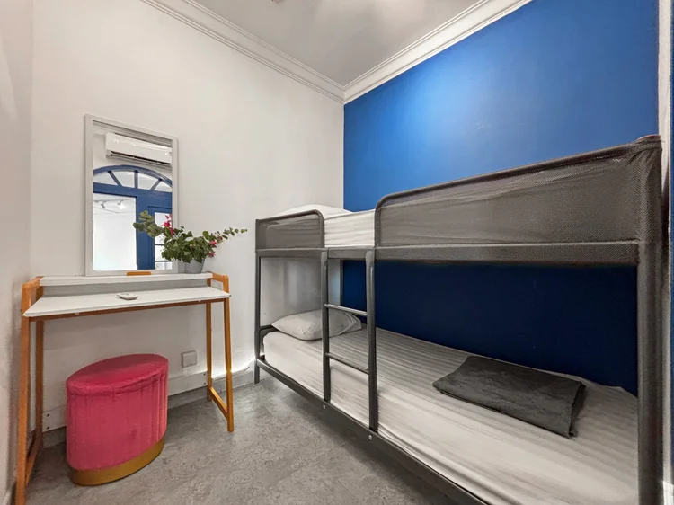 Santorini: A bedroom with a bunk bed, a dressing table and a sea-blue wall.