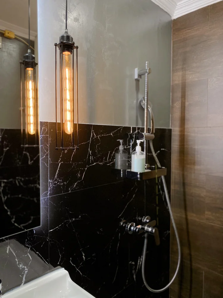 Kingston: A hot-water shower with black marble-look walls.