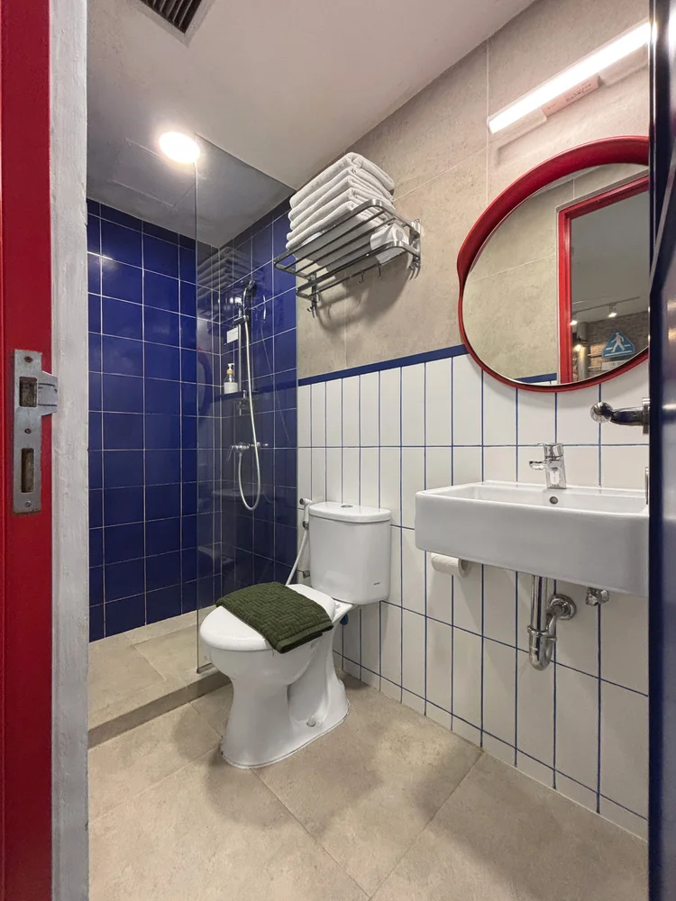 Shibuya: A modern bathroom with a hot shower and blue tiles.