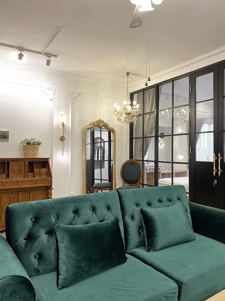 Paris: The green velvet sofa with cushions, a ceiling fan above.