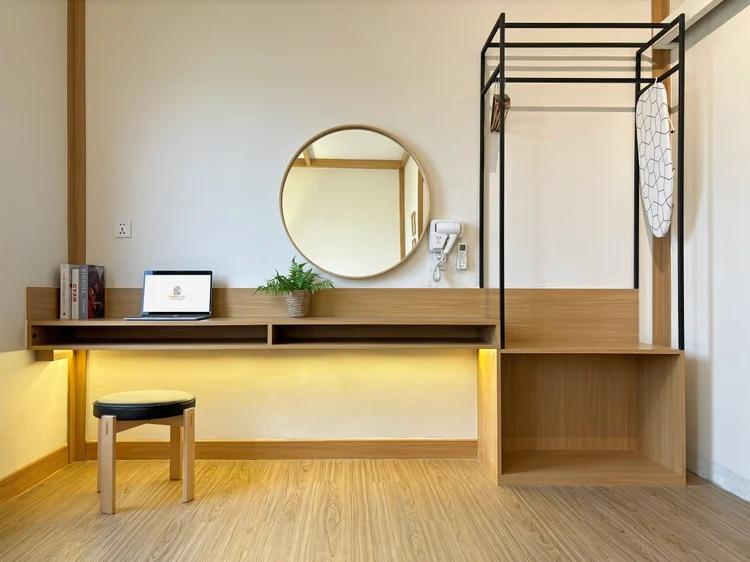Nara: A dressing table with round mirror that doubles as a desk; a clothes rack beside it.