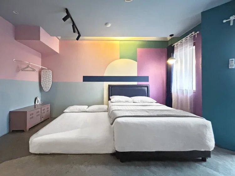 Montreal: The bed area with colour-blocked walls, AC and a 140 cm small double bed.