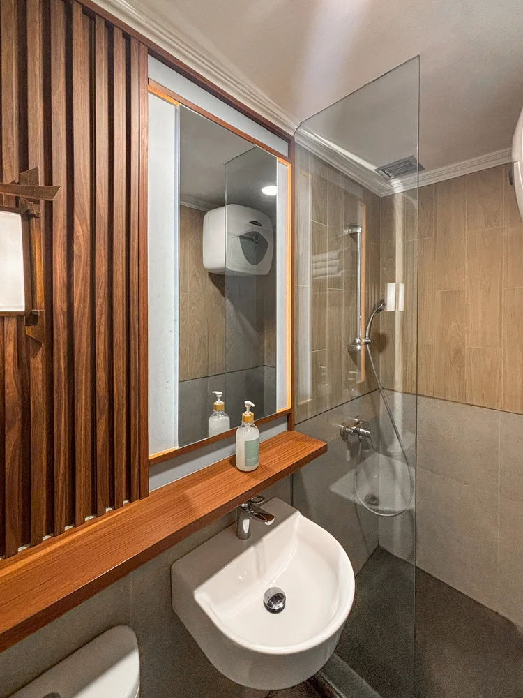 Shinjuku: Glass-walled hot-water shower, cleaned by our own trained team to CHSE standard before every check-in.