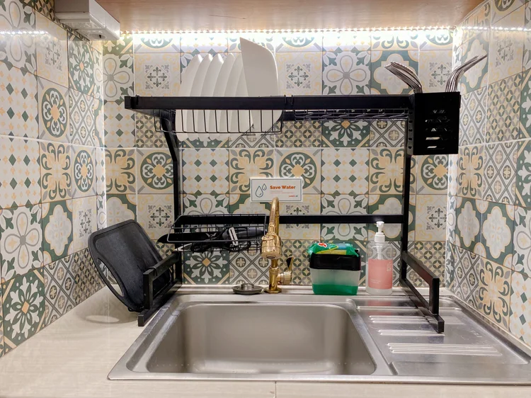 Saigon: Kitchen sink with Peranakan-pattern tiles and a dish rack.