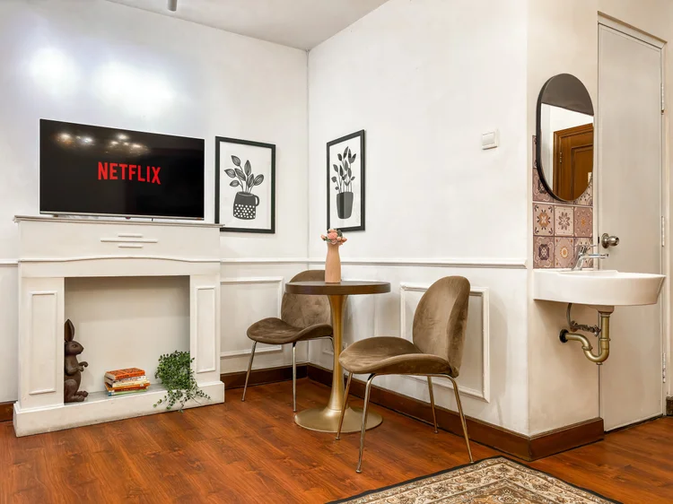 Provence: TV with Netflix above the decorative fireplace, a dining table for two beside it.
