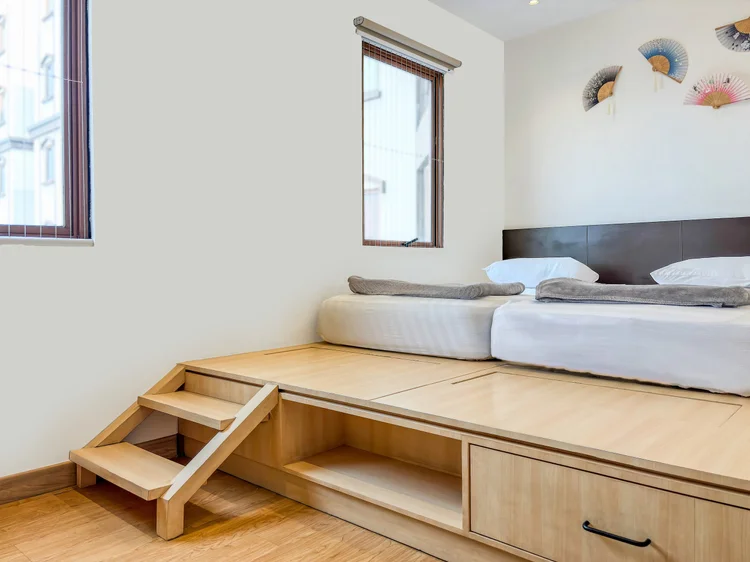 Yokohama: Beds on a raised wood platform, with steps and storage drawers underneath.