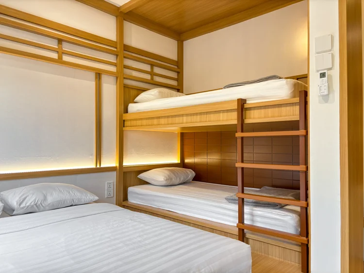 Omotesando: The 90 cm bunk beds beside the floor bed; white sheets as in all our units.