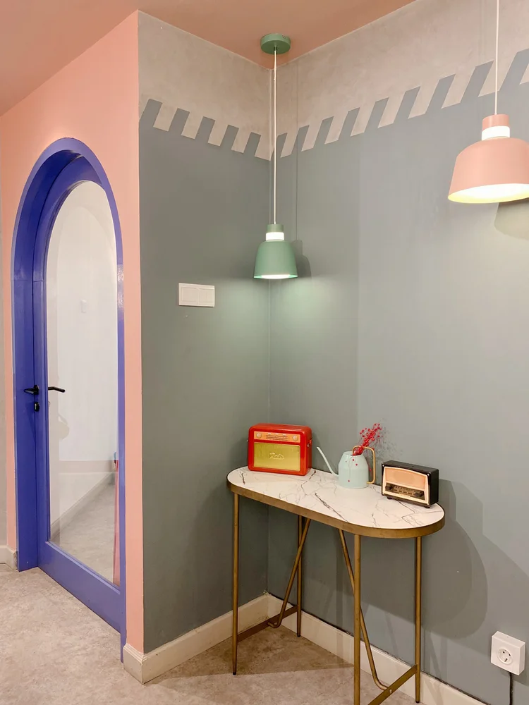 Geneva: A small table with a vintage radio, under the purple arch and pendant lights.