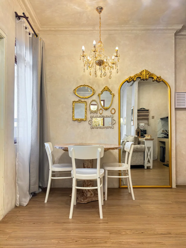 Bordeaux: Dining table for three, with a full-length gold mirror beside it.