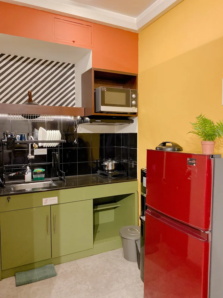Geneva: Fridge and induction stove in the kitchen's bright-colored corner.