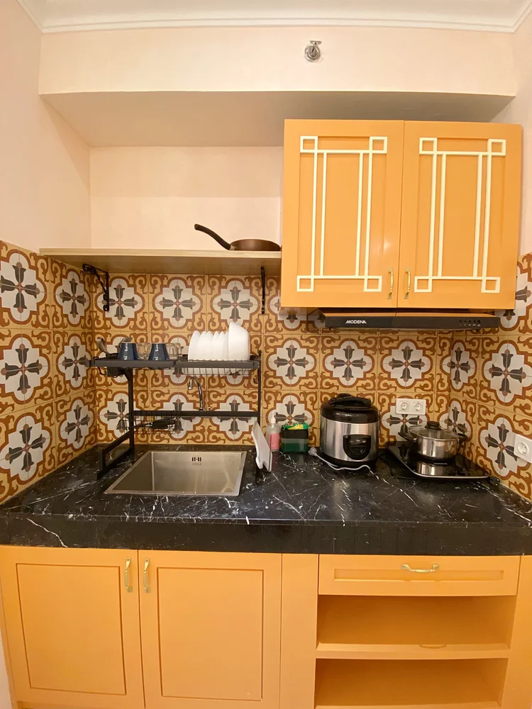 Malacca: Open kitchen: induction stove, rice cooker and Peranakan patterned tiles.