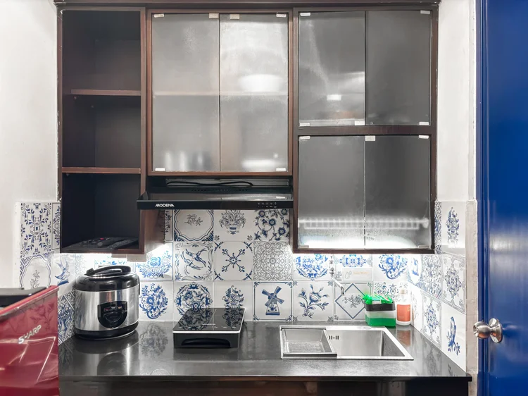 Amsterdam: Delft-pattern tiles in the kitchen, with a rice cooker and induction stove.