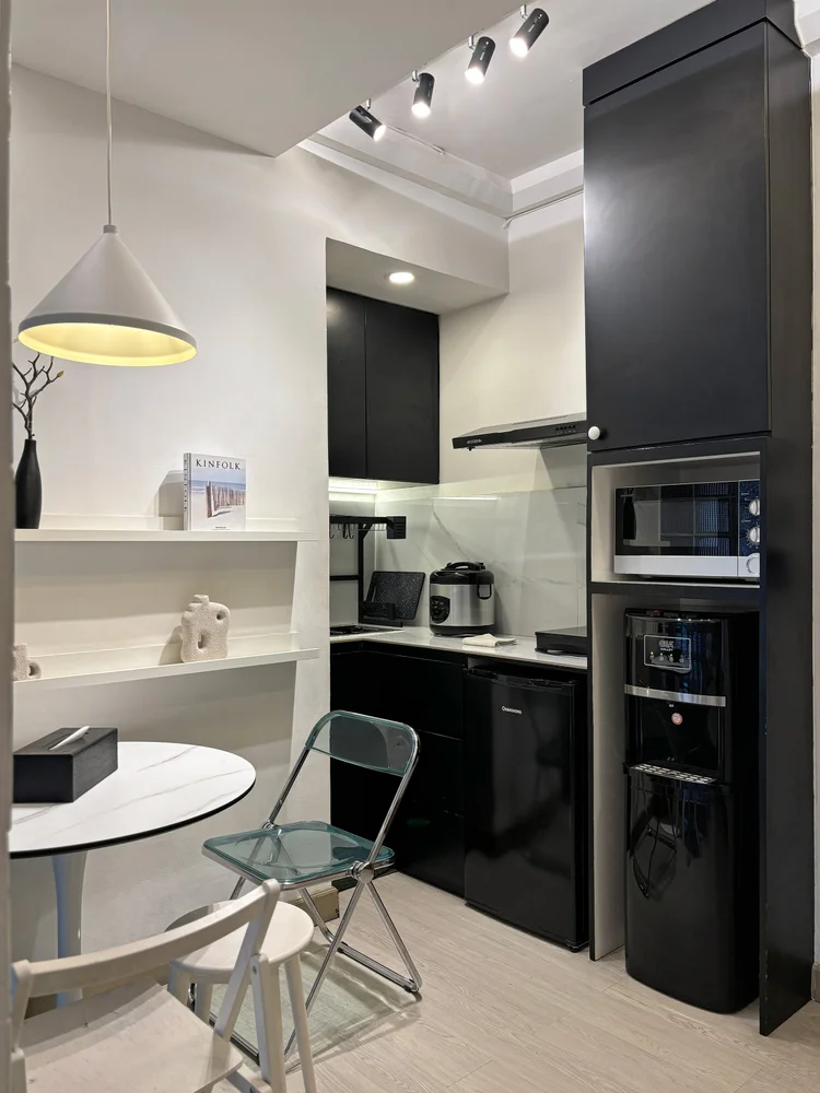 Sydney: Modern open kitchen in black: fridge, microwave and induction stove.