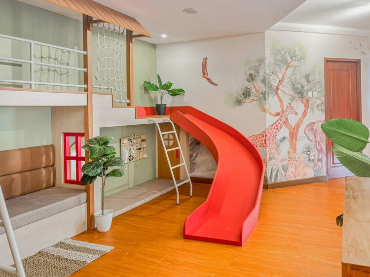 Tanzania: A built-in sofa in the living room, with a red play window and a ladder to the loft.