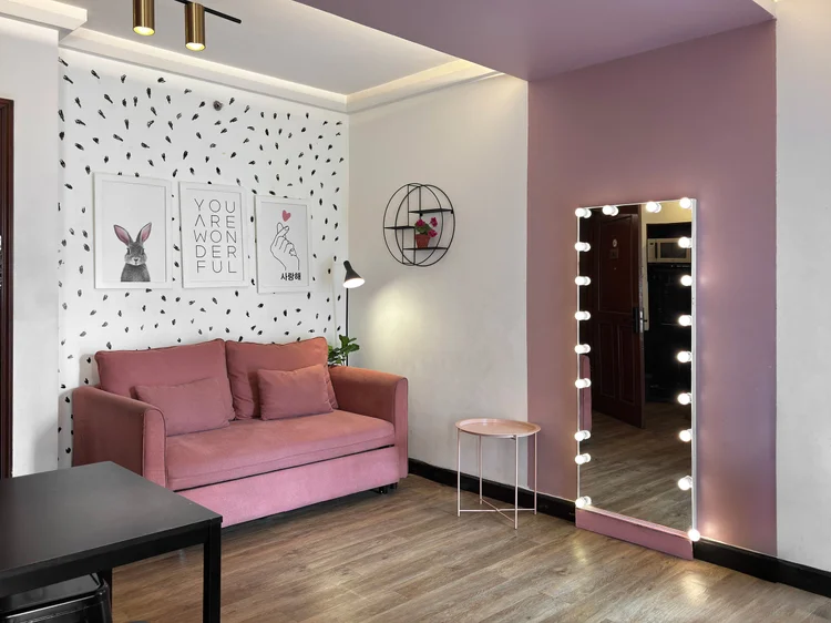 Myeong-dong: A pink sofa against the black-dotted wall, the lit mirror alongside.