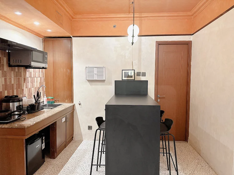 Melbourne: A high dining table with bar stools, right in front of the open kitchen.