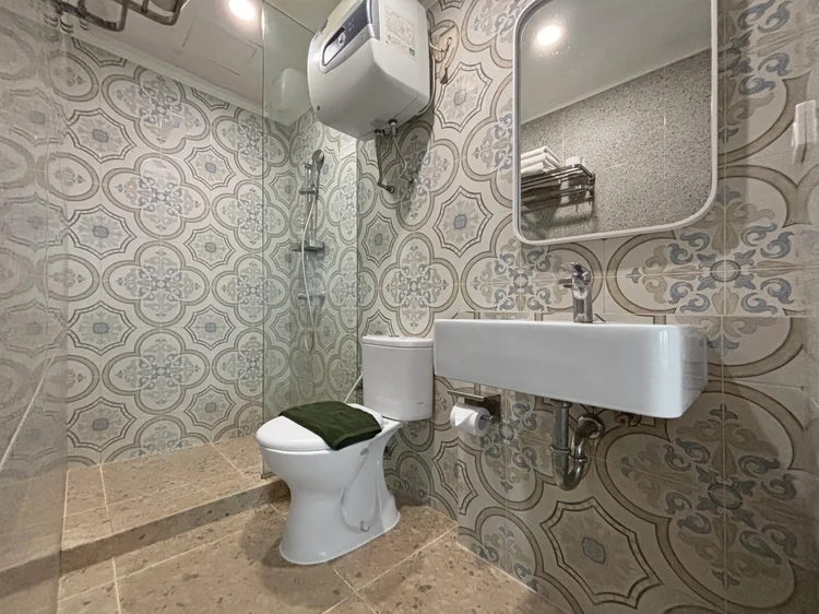 Mykonos: A bathroom with a hot shower and patterned tiles.