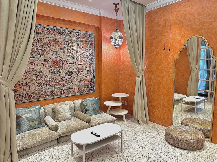 Cappadocia: Turkish Getaway: orange walls, a kilim tapestry and soft curtains in the living room.