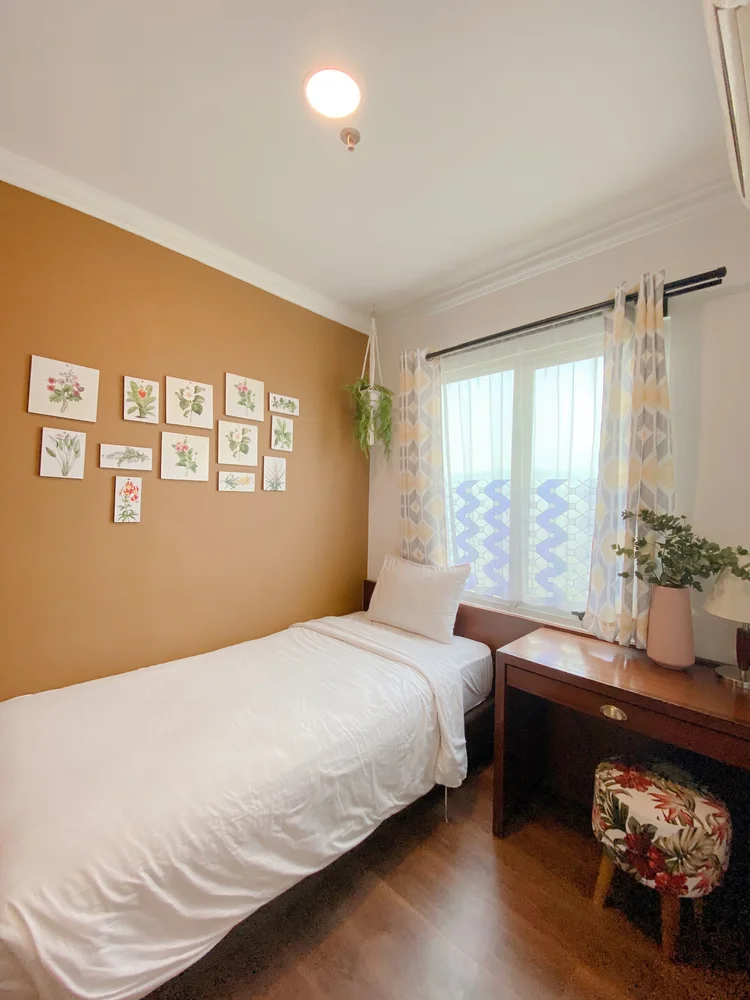 Palermo: Bedroom with a single bed and a table by the window, mustard-yellow wall.