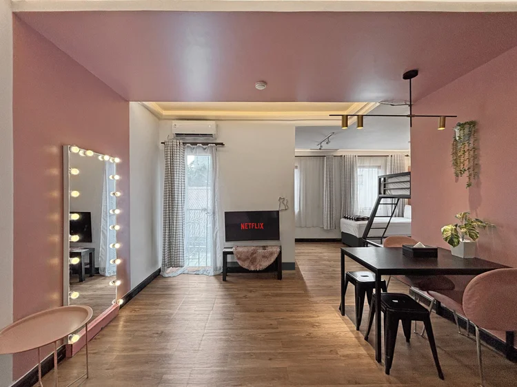 Myeong-dong: A 48 sqm studio in black and pink: lit mirror, TV, dining table and bunk beds.