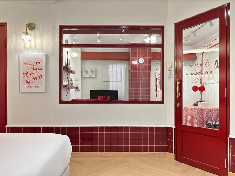Chamonix: Smart TV with Netflix facing the bed, with a mirror and red door beside it.