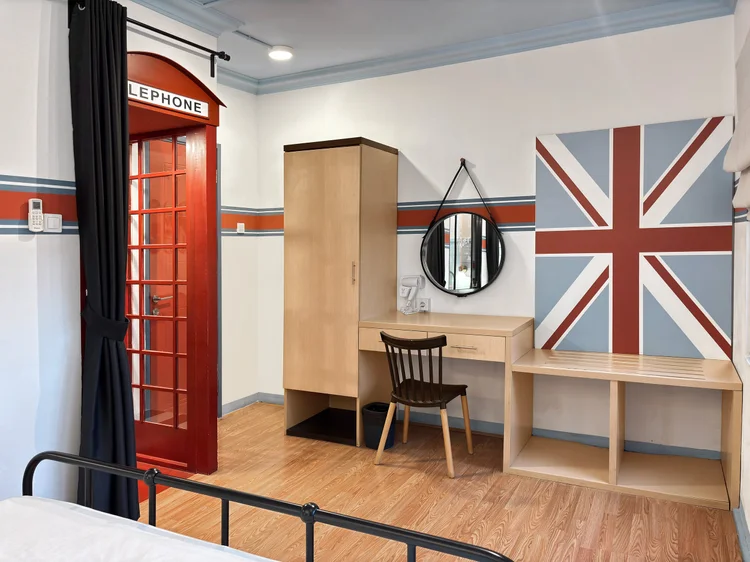 London: A bedroom with a red telephone booth accent and the British flag on the wall.