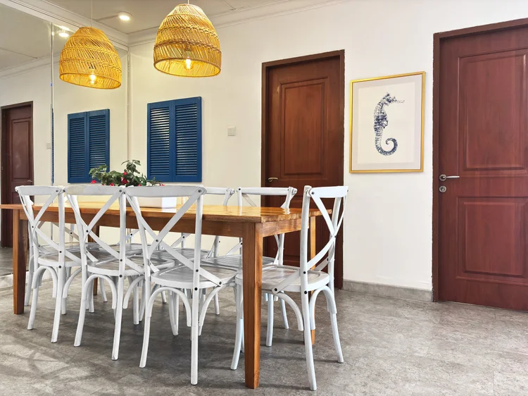 Santorini: White cross-back chairs and rattan pendants over the dining table.