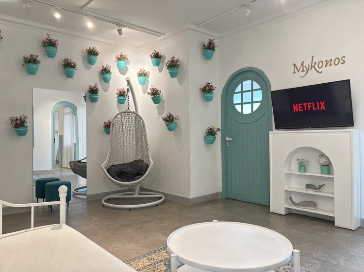 Mykonos: Mykonos-style living room: a hanging chair, flower pots on the wall, smart TV with Netflix.