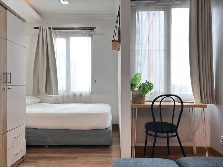Bern: A 120 cm single bed by the window, with a small table and chair.