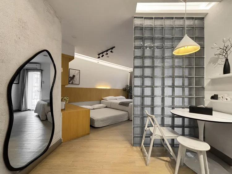 Sydney: A curvy tall mirror, with the bed area and dining table in the same room.