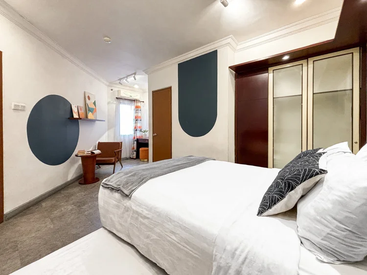 Chicago: A bedroom with a glass-front wardrobe and blue wall, white sheets the same standard in all our units.