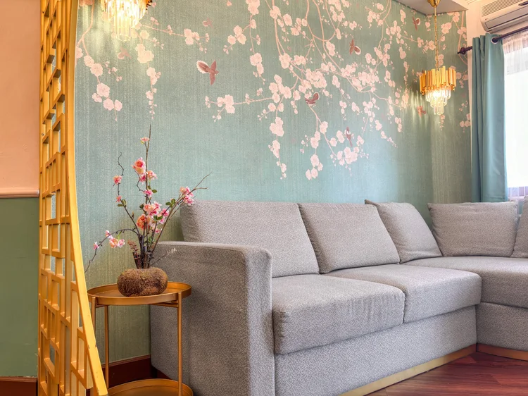 Salzburg: Four-seater sofa against the cherry-blossom wallpaper, the spot to gather after a day out.