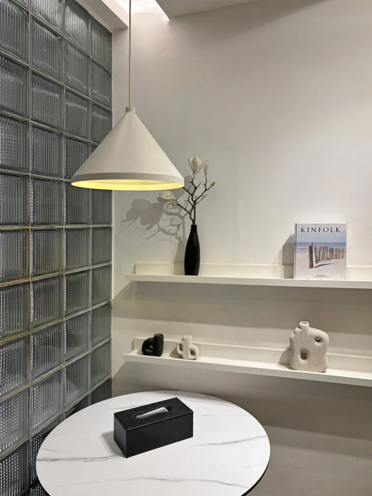 Sydney: White wall shelves and the round table beside the glass-block wall.