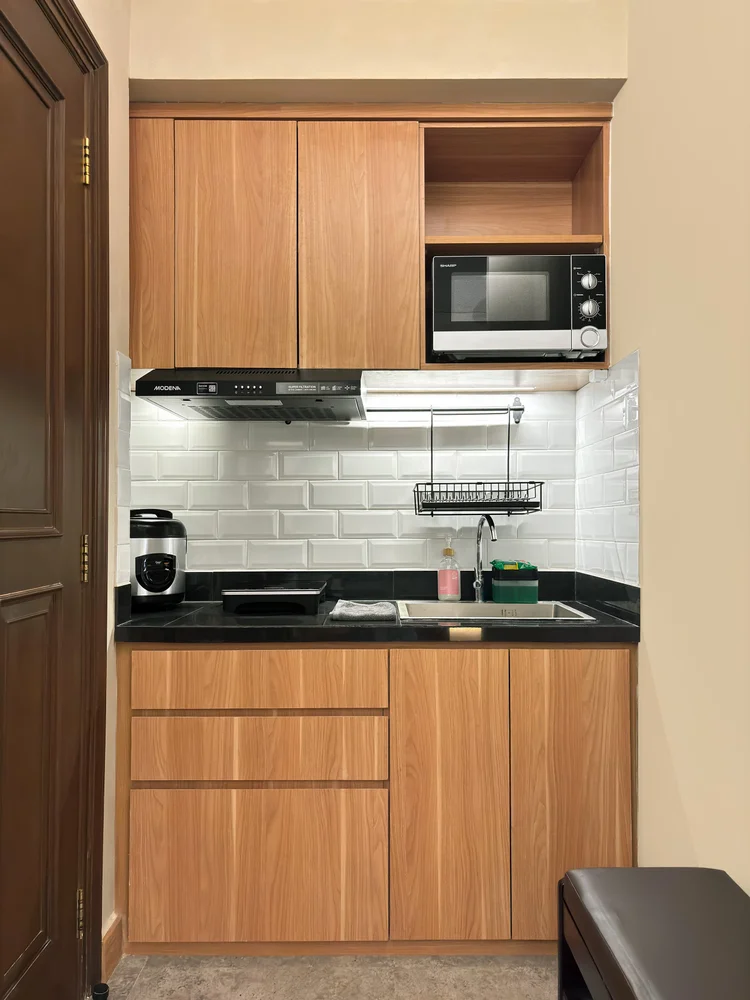 Nakameguro: Open kitchen with microwave, induction hob and wooden cabinets.