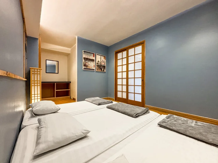 Yokohama: A bedroom with two beds and sliding shoji doors. Sleeps 8, up to 9 with extra beds.