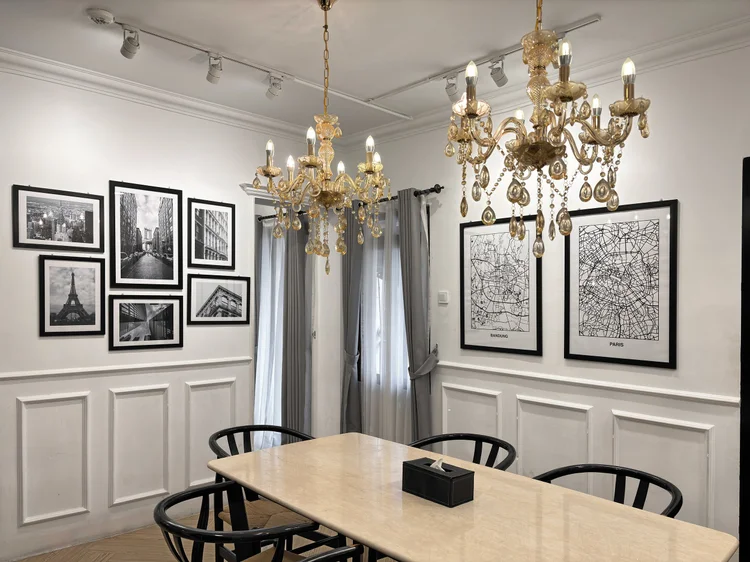 Paris: A crystal chandelier and framed maps of Paris over the dining table.